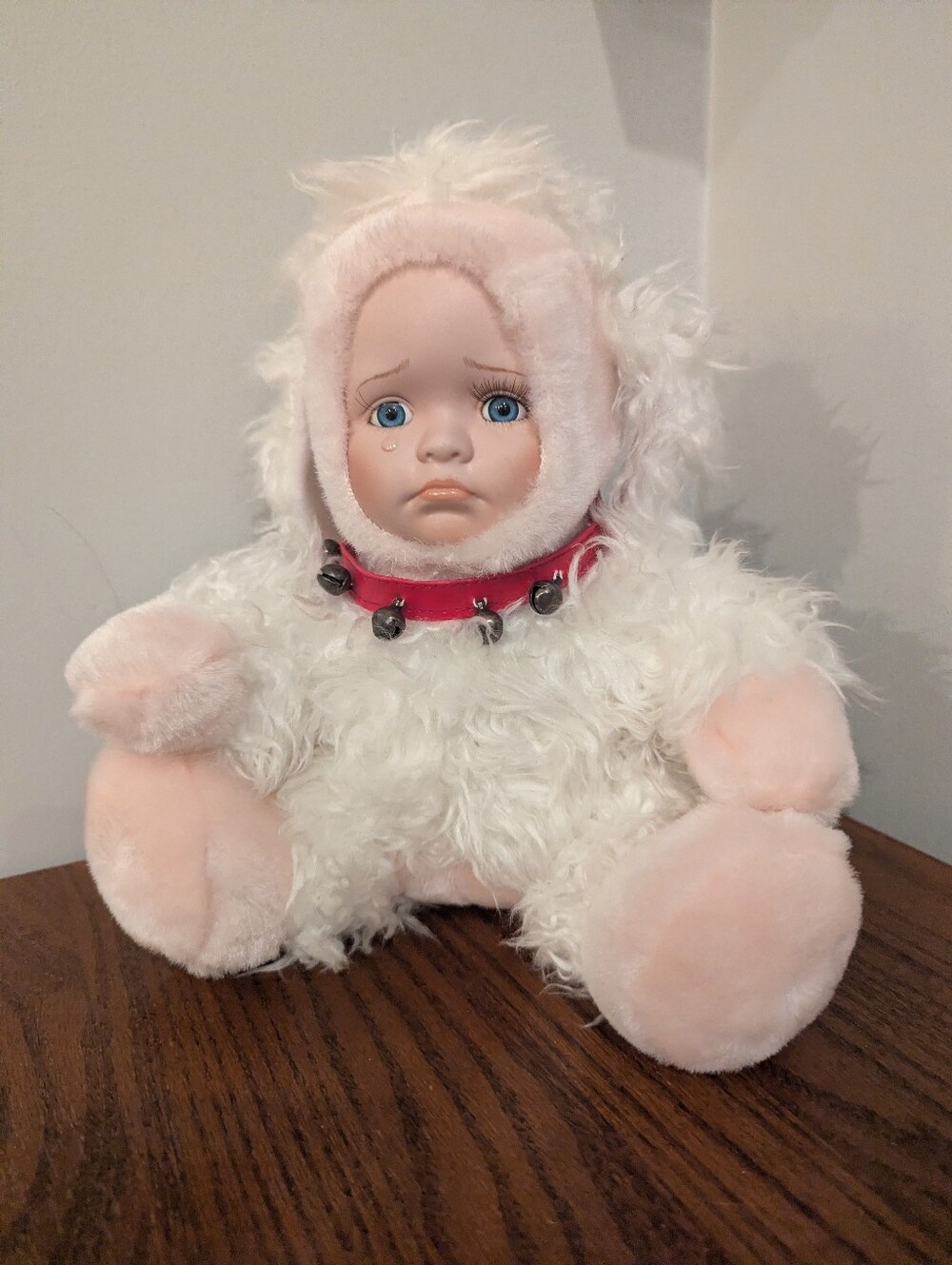 Vintage porcelain doll of a crying baby dressed as a plush lamb Show Stoppers US